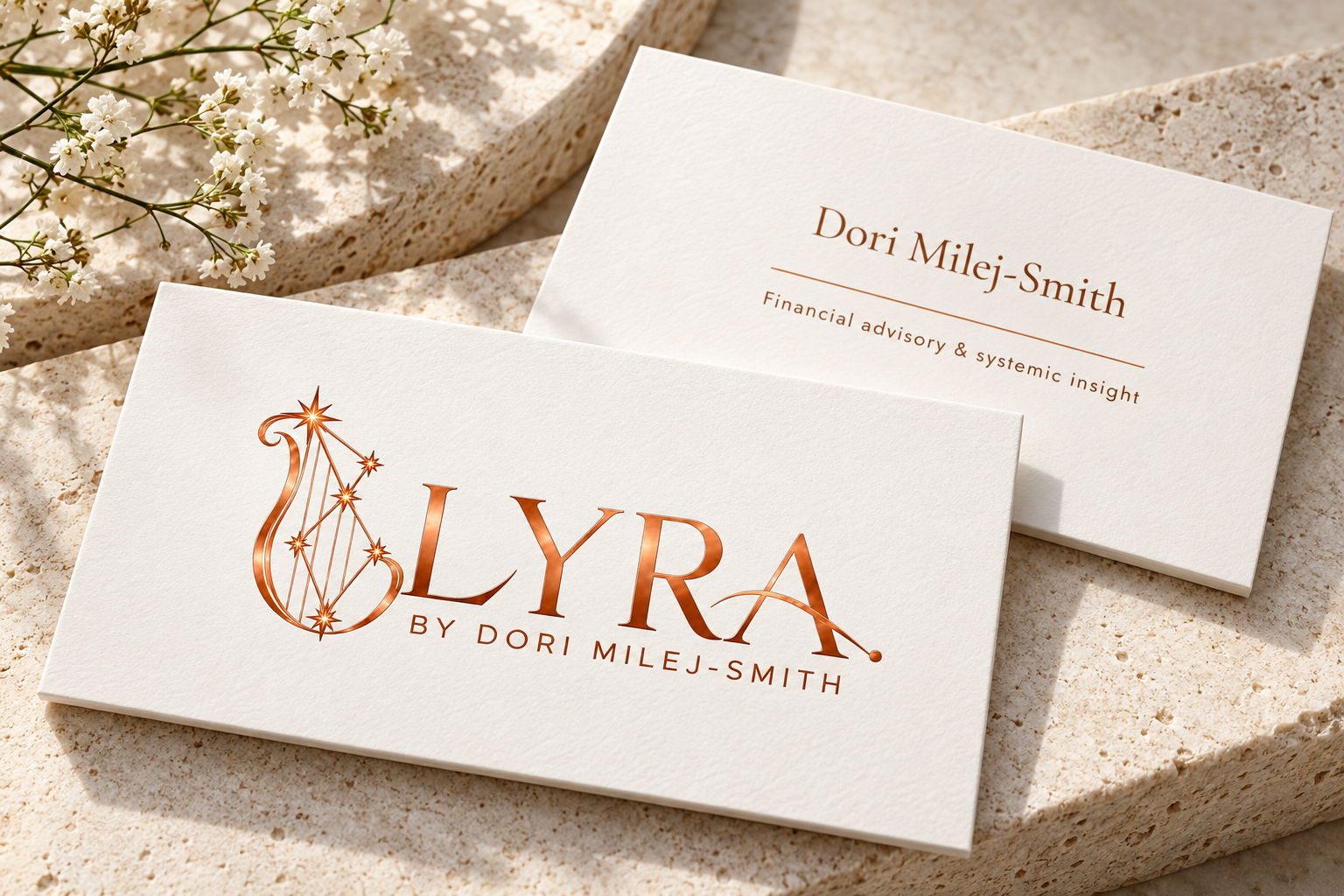 Ivory LYRA business cards with the bronze logo and Dori Milej-Smith's name on pale stone.